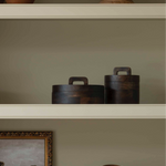 A striking wooden pot with lid in dark wood.