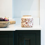 A ceramic planter painted  with a pretty floral design