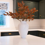 A spray of brown Perilla stems in a white vase