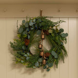 A beautiful full wreath, created using silver dollar eucalyptus, natural eucalyptus, blueberry stems, pine spray and finished with pine cones