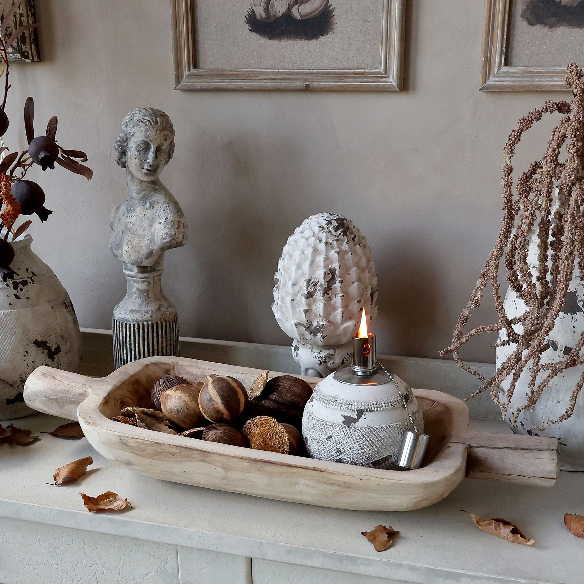 Dough bowl carved from natural wood and filled with walnuts and a candle