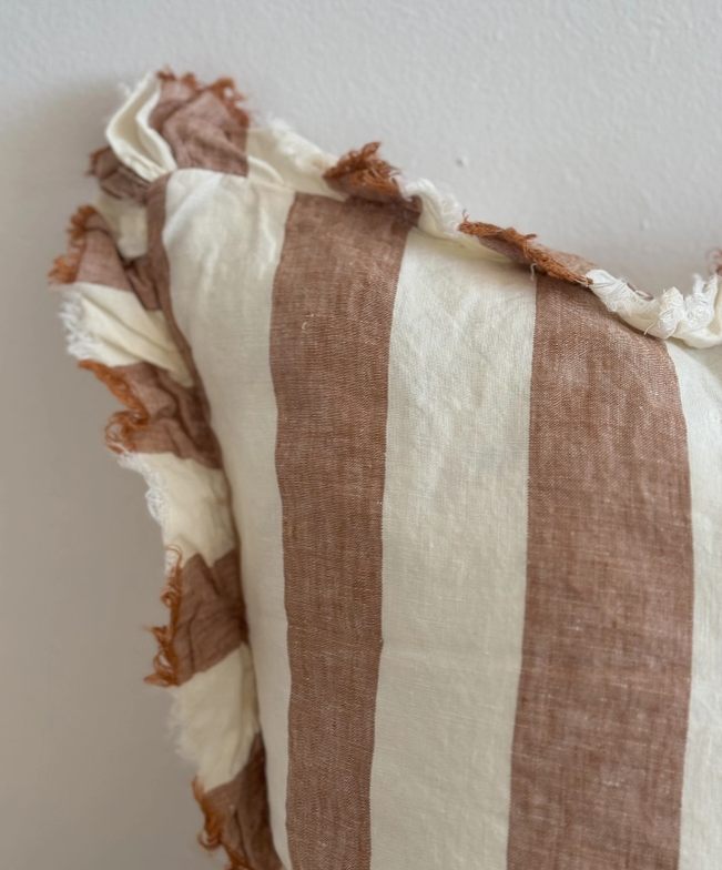 A beautiful linen cushion in a rich rust stripe pattern colour featuring ruffled edges.